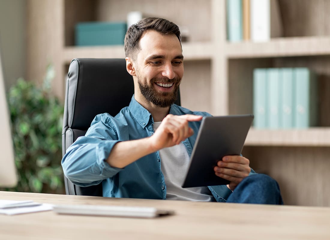 Read Our Reviews - Cheerful Man Using Tablet at Home Office